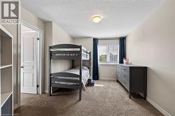 Window with blinds, wall-to-wall carpeting, overhead lighting fixture, and white interior door - 