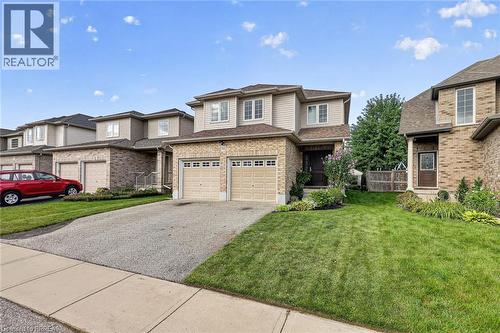 Two-story residence featuring a brick and siding exterior, dual garage doors, and a paved driveway - 783 Frontenac Crescent, Woodstock, ON - Outdoor With Facade