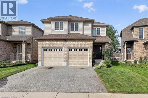 Stone and siding exterior with a two-car garage, front entry, and mature landscaping - 783 Frontenac Crescent, Woodstock, ON - Outdoor With Facade