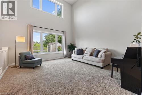 Soaring vaulted ceiling with high-set windows, large picture windows, and neutral carpeting - 783 Frontenac Crescent, Woodstock, ON - Indoor