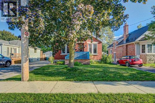 Brick exterior with a covered porch, front lawn, and mature trees - 97 Francis Street, Cambridge, ON - Outdoor