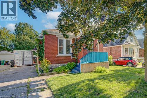 Brick exterior with white-trimmed windows and a vibrant blue porch railing - 97 Francis Street, Cambridge, ON - Outdoor