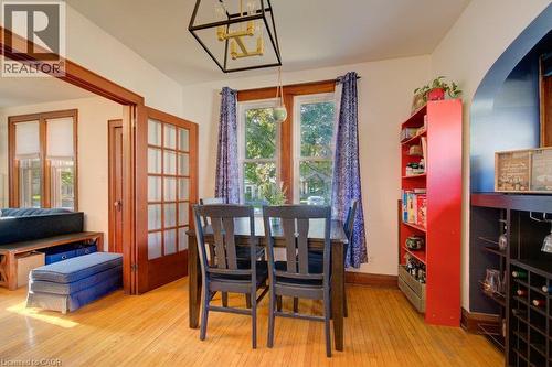 Hardwood flooring, French doors, an arched doorway, a built-in beverage display, and a modern geometric light fixture - 97 Francis Street, Cambridge, ON - Indoor Photo Showing Dining Room