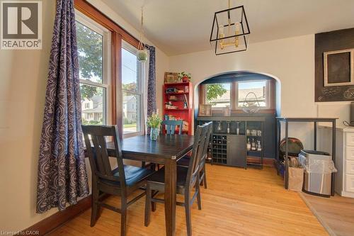 Hardwood-style flooring, a modern geometric chandelier, an arched entryway, and built-in shelving - 97 Francis Street, Cambridge, ON - Indoor Photo Showing Dining Room