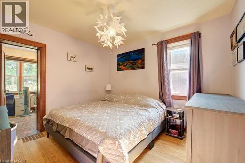 Hardwood flooring with a white pendant light fixture - 97 Francis Street, Cambridge, ON - Indoor Photo Showing Bedroom