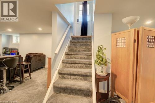 Carpeted staircase with white handrail leading to an interior door - 97 Francis Street, Cambridge, ON - Indoor Photo Showing Other Room
