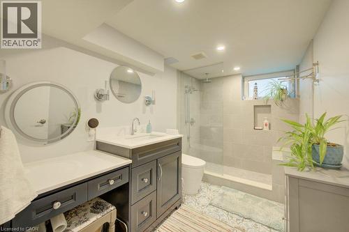 Vanity with integrated sink, walk-in shower with glass enclosure, recessed lighting, and wall-mounted mirrors - 97 Francis Street, Cambridge, ON - Indoor Photo Showing Bathroom