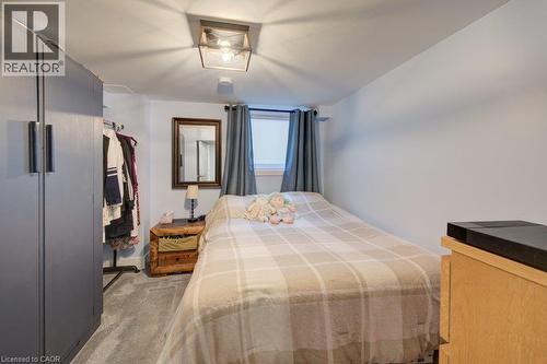 Recessed window with drapes, built-in wardrobe, ceiling-mounted light fixture, light-toned walls, and carpet flooring - 97 Francis Street, Cambridge, ON - Indoor Photo Showing Bedroom