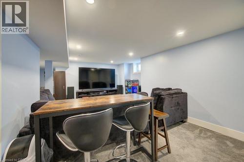 Recessed lighting, wood-finish bar top, built-in media console, light blue wall paint, and gray carpeting - 97 Francis Street, Cambridge, ON - Indoor