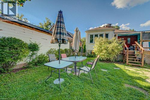 Expansive green lawn with mature perimeter shrubbery, featuring a multi-level wood deck structure - 97 Francis Street, Cambridge, ON - Outdoor With Deck Patio Veranda