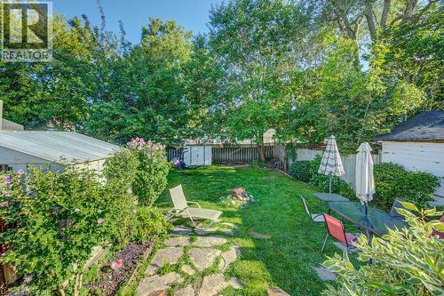 Expansive green lawn with mature perimeter trees, stone paver pathway, and garden beds - 97 Francis Street, Cambridge, ON - Outdoor