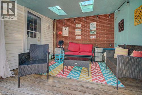 Covered patio featuring wood-finish flooring, exposed brick wall, skylights, and string lighting - 97 Francis Street, Cambridge, ON -  With Exterior
