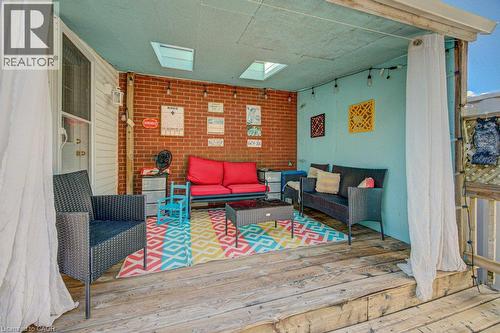 Covered outdoor space featuring a brick accent wall, wood-finish decking, and skylights - 97 Francis Street, Cambridge, ON - Outdoor With Deck Patio Veranda With Exterior