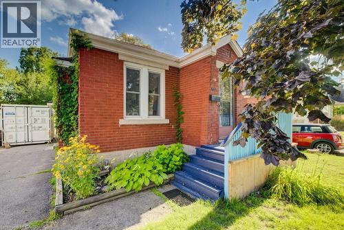 Red brick exterior with white trim windows and a painted wooden porch - 97 Francis Street, Cambridge, ON - Outdoor