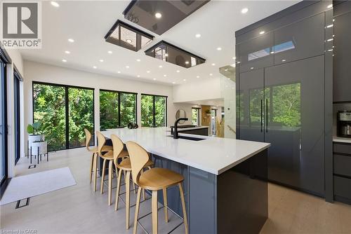 Spacious kitchen featuring an oversized island with a white countertop, integrated sink, and matte black faucet - 282 Robina Road, Ancaster, ON - Indoor