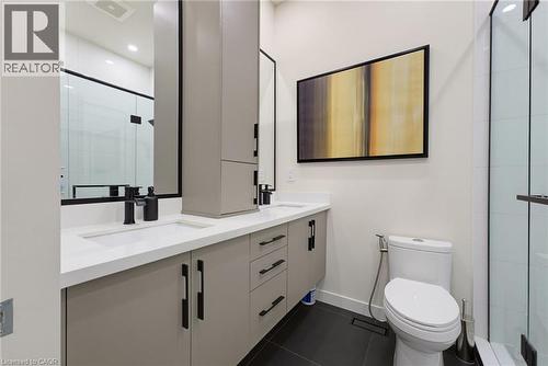Dual vanity featuring light gray cabinetry with black hardware, white countertops, and integrated rectangular sinks - 282 Robina Road, Ancaster, ON - Indoor Photo Showing Bathroom
