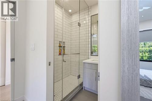 Contemporary bathroom featuring a frameless glass shower enclosure with subway tile surround, hexagon tile flooring, and a built-in shower niche - 282 Robina Road, Ancaster, ON - Indoor Photo Showing Bathroom
