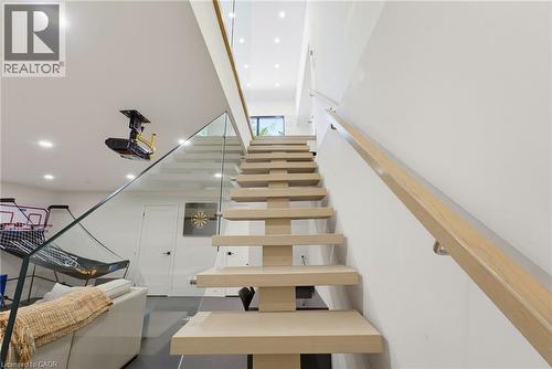 Modern open-tread staircase with light wood steps and a glass railing system - 282 Robina Road, Ancaster, ON - Indoor Photo Showing Other Room