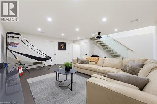 Brightly lit lower level featuring recessed lighting and a contemporary glass and wood staircase - 282 Robina Road, Ancaster, ON - Indoor