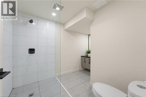 Modern bathroom featuring a glass-enclosed shower with white horizontally-stacked subway tile and matte black fixtures - 282 Robina Road, Ancaster, ON - Indoor Photo Showing Bathroom