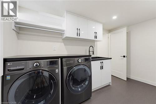 Dedicated laundry room featuring a utility sink with a matte black faucet, ample white cabinetry, and a countertop workspace - 282 Robina Road, Ancaster, ON - Indoor Photo Showing Laundry Room