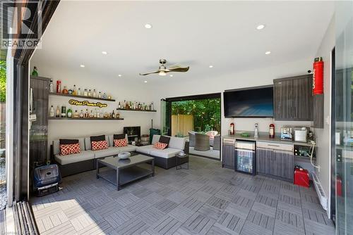 Spacious covered patio featuring a built-in bar with beverage refrigerator, ceiling fan, recessed lighting, and sliding glass doors opening to an outdoor area - 282 Robina Road, Ancaster, ON - Indoor