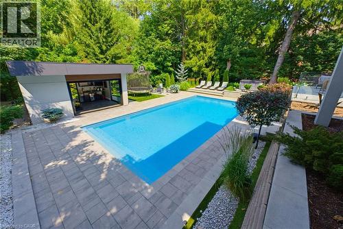Rectangular inground swimming pool with a surrounding paver patio - 282 Robina Road, Ancaster, ON - Outdoor With In Ground Pool