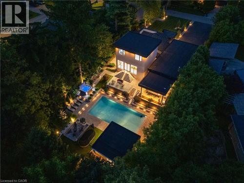 Expansive outdoor living area featuring a rectangular swimming pool, integrated hot tub, and multiple paved patio spaces - 282 Robina Road, Ancaster, ON - Outdoor With In Ground Pool With View
