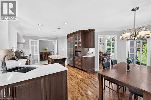 Hardwood flooring, recessed lighting, white perimeter cabinetry, dark wood island with light countertop, and a built-in refrigerator - 11 Christman Court, Markham, ON - Indoor