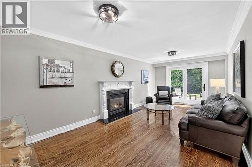 Hardwood flooring, fireplace with ornate mantel, crown molding, sliding glass doors, and recessed lighting - 11 Christman Court, Markham, ON - Indoor Photo Showing Living Room With Fireplace