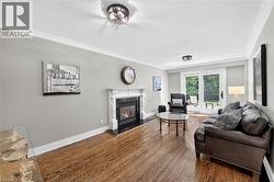 Hardwood flooring, fireplace with ornate mantel, crown molding, sliding glass doors, and recessed lighting - 