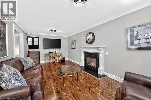 Hardwood flooring, crown molding, built-in fireplace with decorative mantel, black stone hearth, and recessed lighting - 11 Christman Court, Markham, ON - Indoor Photo Showing Living Room With Fireplace