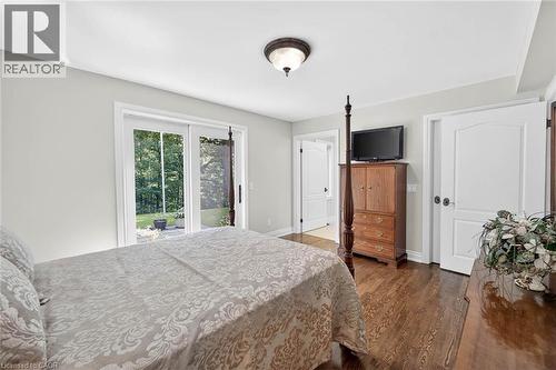 Hardwood flooring, white interior doors, sliding glass patio doors, and a flush mount ceiling light fixture - 11 Christman Court, Markham, ON - Indoor Photo Showing Bedroom