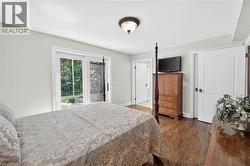 Hardwood flooring, white interior doors, sliding glass patio doors, and a flush mount ceiling light fixture - 