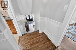 Hardwood flooring, wainscoting, light gray wall paint, and white trim - 