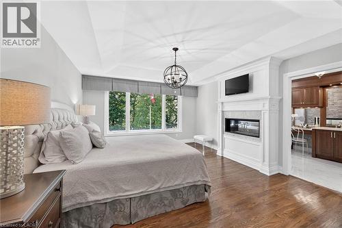 Tray ceiling, wood-finish flooring, built-in fireplace, large window, and recessed lighting - 11 Christman Court, Markham, ON - Indoor Photo Showing Bedroom