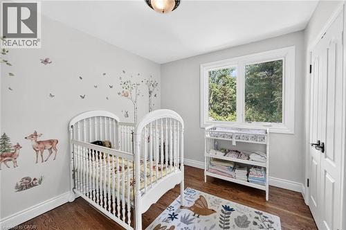 Recessed ceiling light fixture, hard surface flooring, white trim, white window frame, and white paneled door with black hardware - 11 Christman Court, Markham, ON - Indoor Photo Showing Bedroom