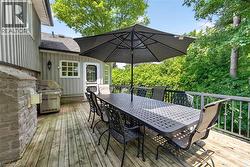 Expansive wood deck with a stone-clad outdoor cooking area and a metal railing system - 