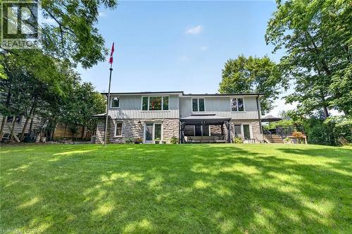 Expansive rear lawn with mature trees and a multi-level structure featuring stone and horizontal siding - 11 Christman Court, Markham, ON - Outdoor With Deck Patio Veranda