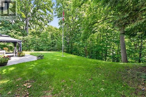 Expansive backyard featuring a manicured lawn, established trees, and a stone paver patio with a built-in gazebo - 11 Christman Court, Markham, ON - Outdoor