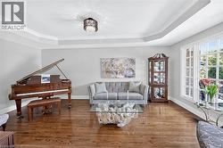 Hardwood flooring, tray ceiling, crown molding, double-pane windows, and a decorative chandelier - 