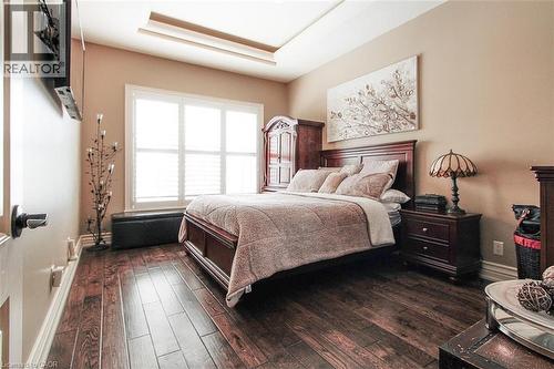 Bedroom featuring dark wood finished floors and a tray ceiling - 205 Paige Place, Kitchener, ON 