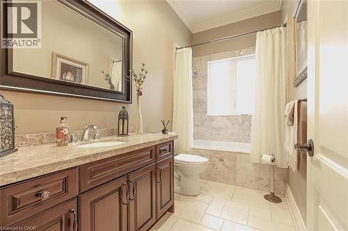 Full bath featuring vanity, crown molding, tiled shower / bath combo, and stone tile floors - 205 Paige Place, Kitchener, ON 