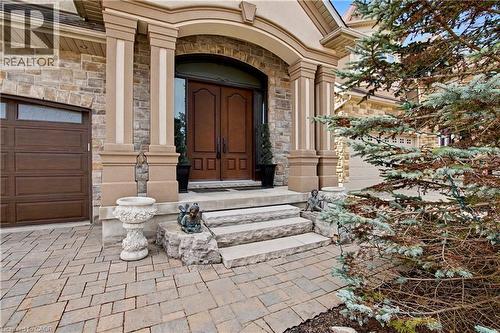 Doorway to property featuring stone siding and a garage - 205 Paige Place, Kitchener, ON 