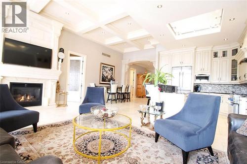 Living area with coffered ceiling, a glass covered fireplace, arched walkways, recessed lighting, and a skylight - 205 Paige Place, Kitchener, ON 