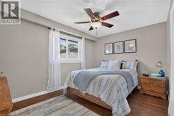 2nd bedroom features hardwood-finish flooring, ceiling fan with integrated lighting, and neutral wall paint - 