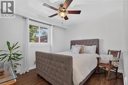 3rd bedroom features hardwood-finish flooring, ceiling fan with integrated lighting, and neutral wall paint - 