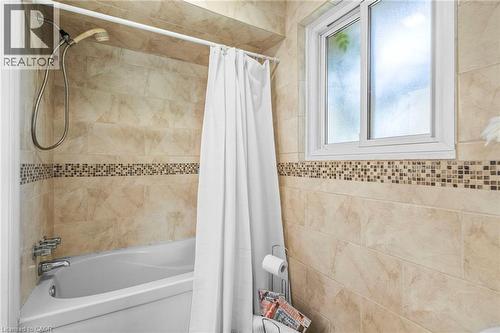 Bathtub-shower combination featuring a tiled surround with a decorative mosaic accent band - 1083 Melton Drive, Mississauga, ON 