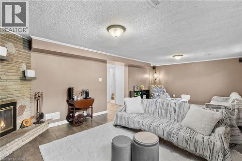 Spacious rec / family room featuring a stone fireplace with hearth, wood-finish flooring, and recessed lighting - 1083 Melton Drive, Mississauga, ON 