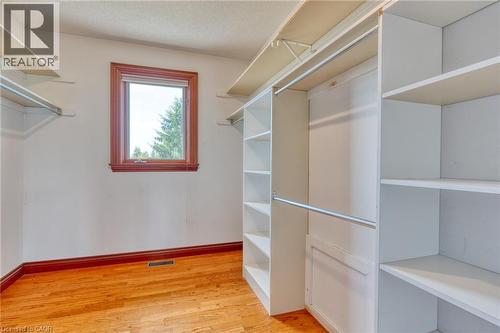 Hardwood flooring, wood-framed window, and built-in closet shelving with hanging rods - 23 Susan Drive, Hamilton, ON 